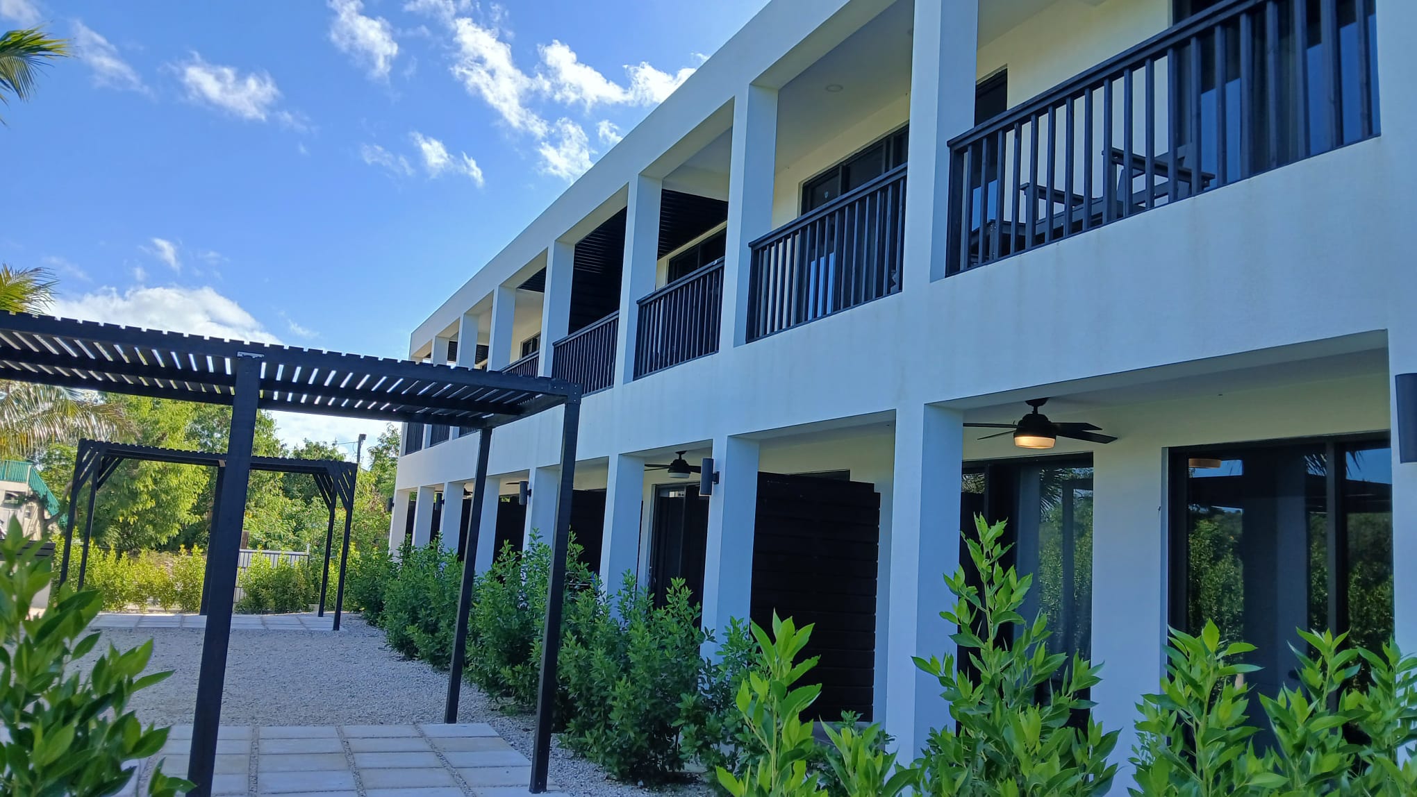 Modern two-storey apartment building with covered walkways and landscaped surroundings